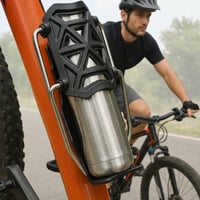 El mismo ciclista pedaleando tranquilo con el termo sujeto por el portabidón en el cuadro
